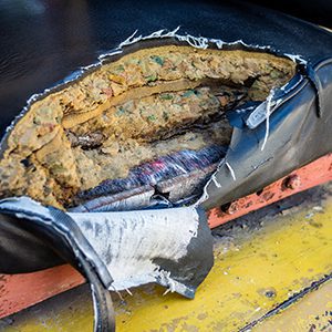 Ripped leather forklift seat with padding showing through