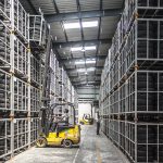 Forklift truck lifting a cage at full reach